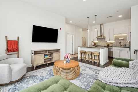 a living room with a couch and a table in front of a kitchen